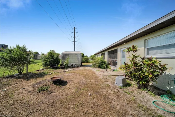 View of yard featuring a shed and a fire pit