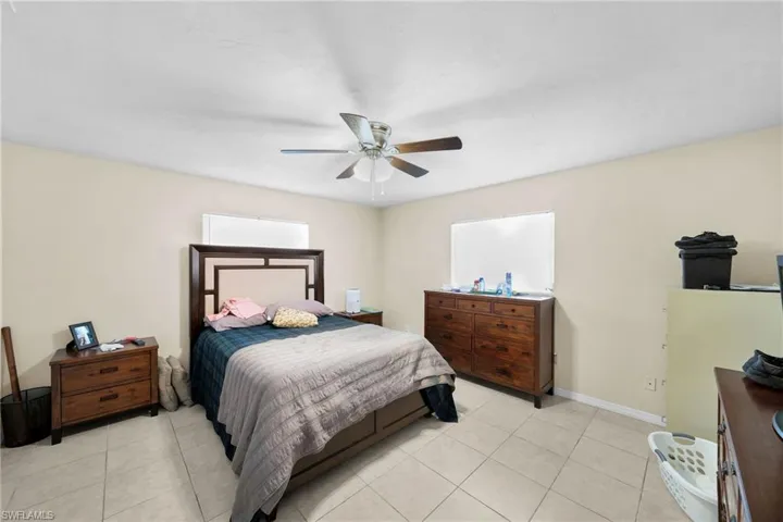 Tiled bedroom featuring ceiling fan