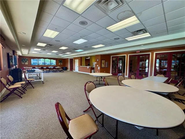 Carpeted dining space with visible vents and a drop ceiling