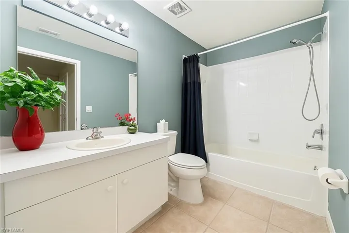 Bathroom featuring tile patterned floors, shower / bath combo, and vanity