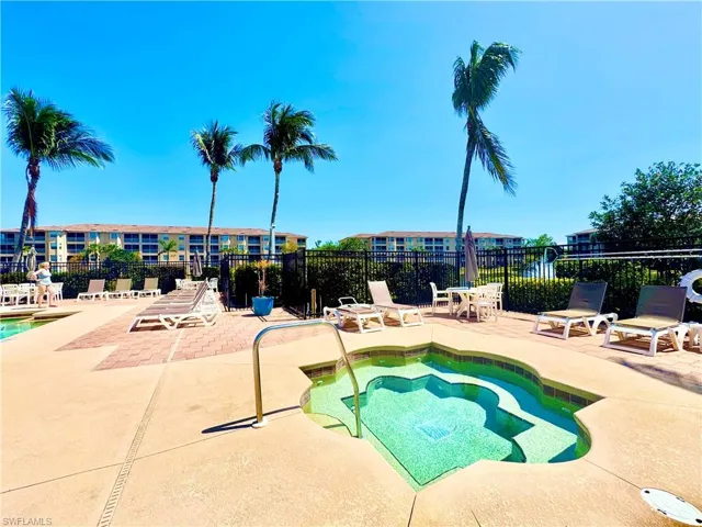 View of pool with a patio, a hot tub, and fence