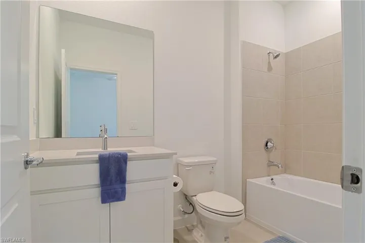 White vanity with a light-toned countertop and an undermount sink