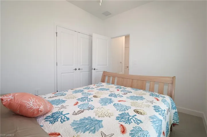 White walls with a vaulted ceiling, wood-finish flooring, and white double-panel doors