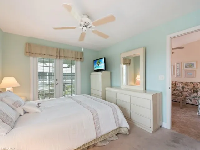 Bedroom with light colored carpet, access to exterior, ceiling fan, and french doors