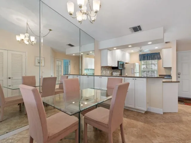 Dining space with ceiling fan with notable chandelier