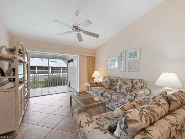 Tiled living room featuring vaulted ceiling and ceiling fan
