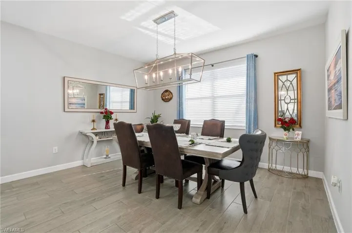 Dining room with suspended lighting, light wood finished floors, and plenty of natural light