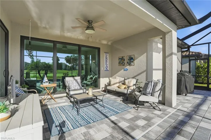 View of patio with a lanai, a sunroom, ceiling fan, outdoor furniture, and area for grilling