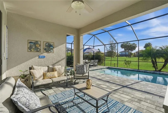 View of patio with a sunroom, a ceiling fan, outdoor lounge area, an outdoor pool, and a lanai