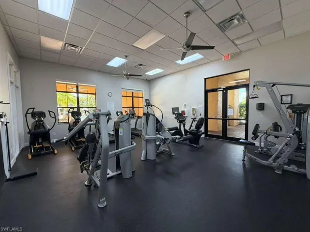 Workout area with a paneled ceiling, ceiling fan, and french doors