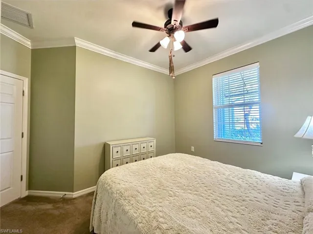 Bedroom featuring crown molding, carpet floors, and ceiling fan