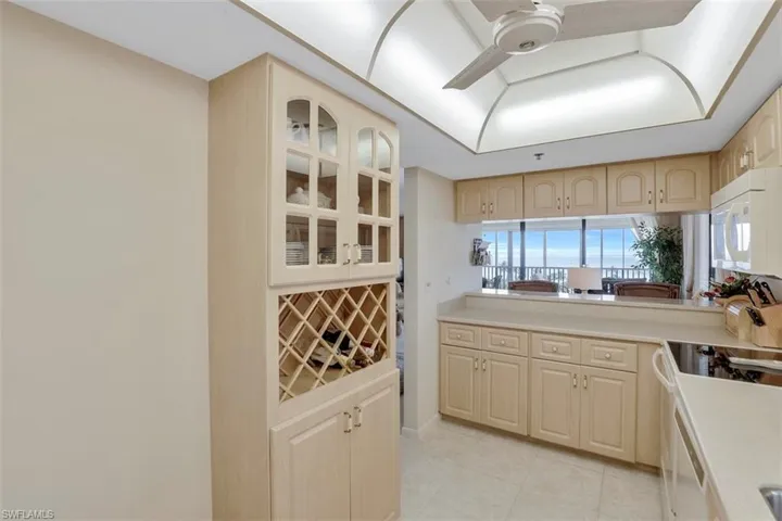 Kitchen with range with electric cooktop, light brown cabinetry, and ceiling fan