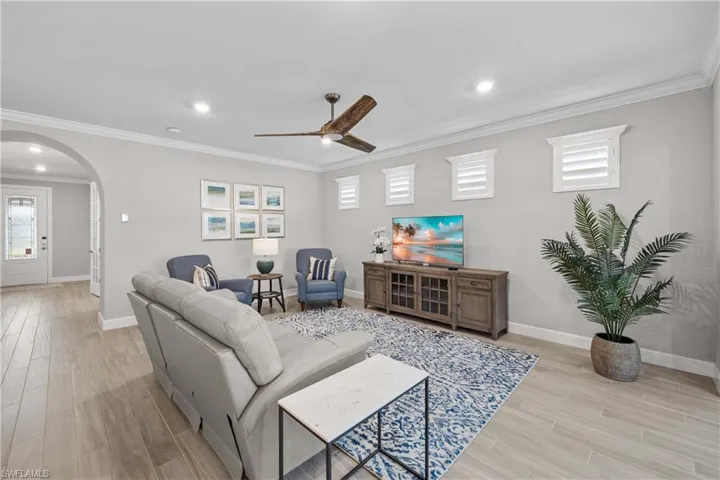 Great room featuring crown molding and a healthy amount of sunlight from