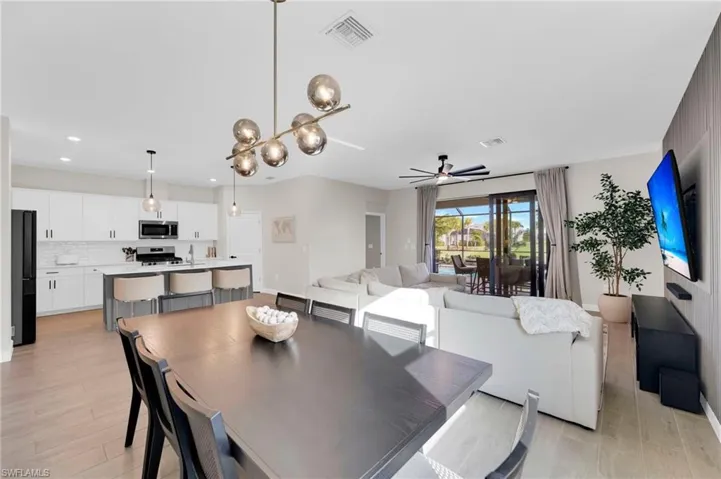 Dining room featuring a chandelier, ceiling fan, and light wood-style flooring