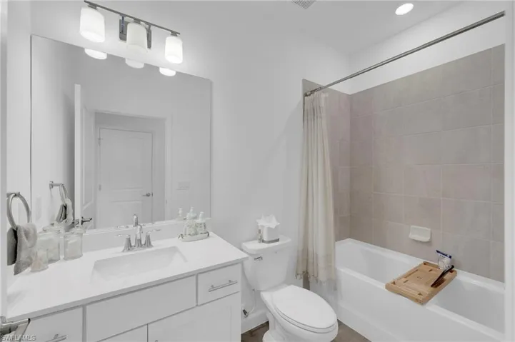 Bathroom with shower / bathtub combination with curtain and vanity