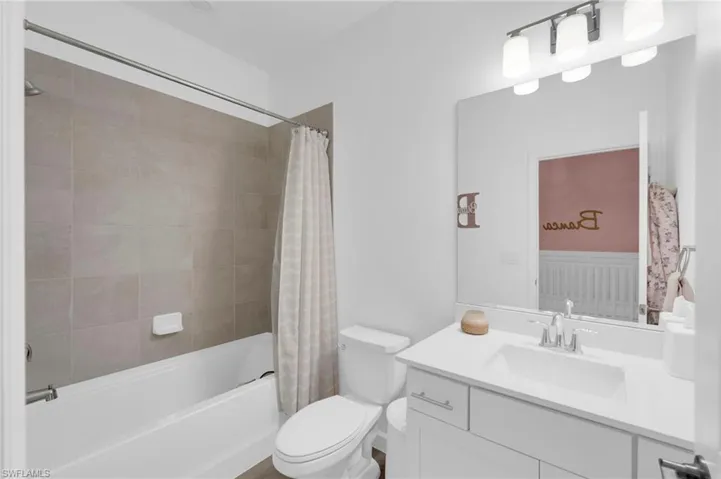 Bathroom with shower / bathtub combination with curtain and vanity