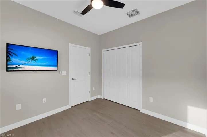 Unfurnished bedroom featuring wood finished floors, a closet, and ceiling fan