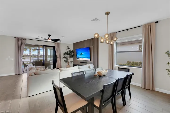 Dining area featuring light wood-type flooring, ceiling fan, and a chandelier