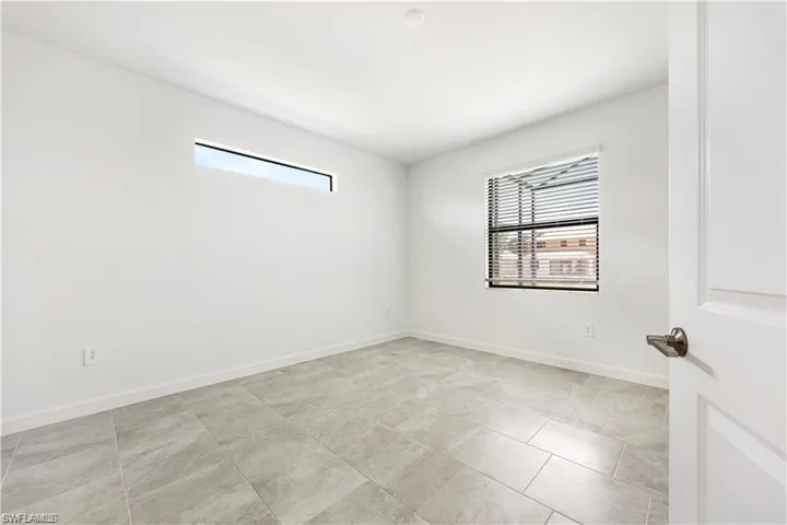 Porcelain tile flooring, horizontal window, additional window with blinds, white interior door, brushed nickel hardware