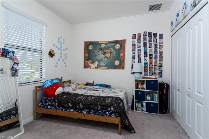 Bedroom with crown molding, a closet, and carpet flooring