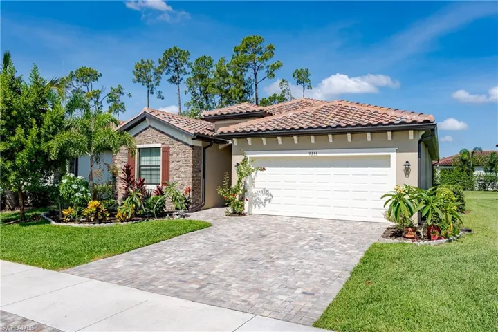 View of front of property featuring a garage and a front lawn