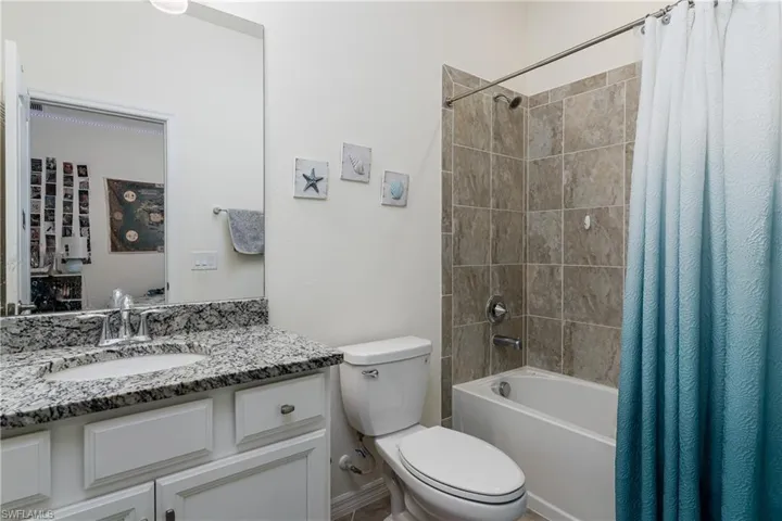 Full bathroom featuring toilet, shower / tub combo with curtain, and vanity