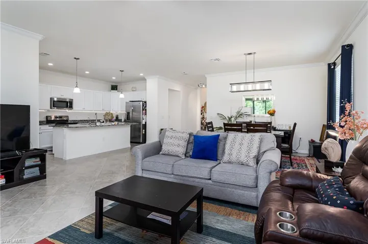 Tiled living room featuring sink and ornamental molding