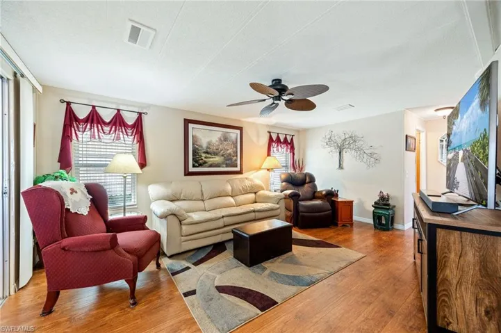 Living area with hardwood / wood-style floors, ceiling fan, and a textured ceiling