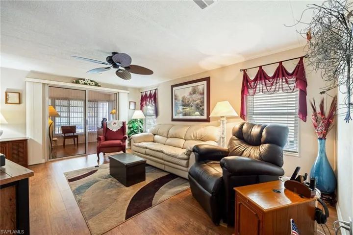 Living area featuring ceiling fan, hardwood / wood-style floors, plenty of natural light, and a textured ceiling