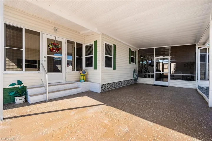 View of patio with a sunroom, a carport, and entry steps