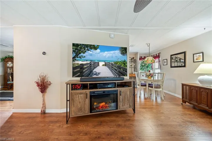 Living room with wood finished floors and a glass covered fireplace