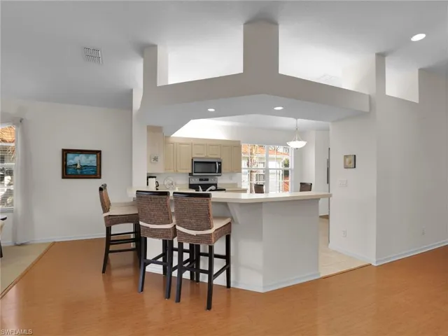 Kitchen featuring stainless steel appliances, light hardwood / wood-style floors, a kitchen bar, and kitchen peninsula