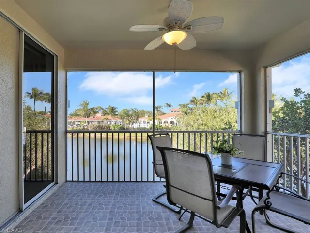 Sunroom with ceiling fan and a water view