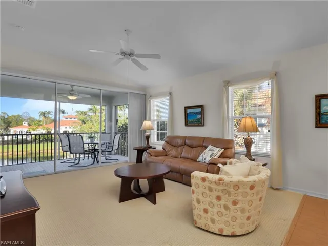Living room featuring lofted ceiling, ceiling fan, and light hardwood / wood-style floors