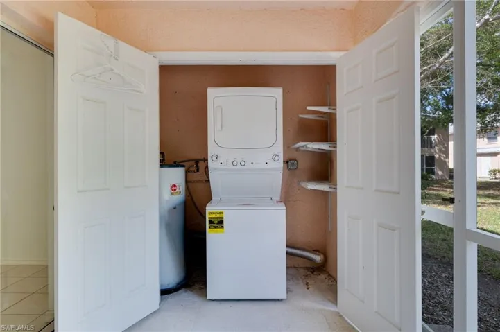 Laundry area with stacked washer / drying machine and water heater
