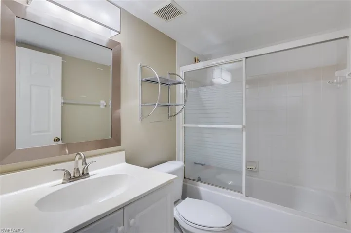 Bathroom with vanity and enclosed tub / shower combo