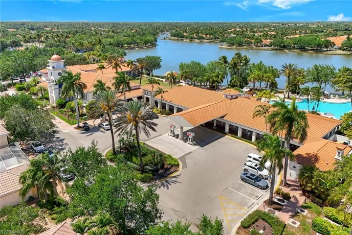 Expansive property featuring a terracotta-tiled roof, a prominent bell tower, and a large lakefront swimming pool