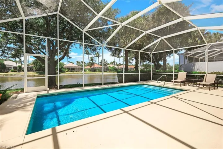 Screened enclosure featuring an in-ground swimming pool, spacious deck area, and direct water frontage