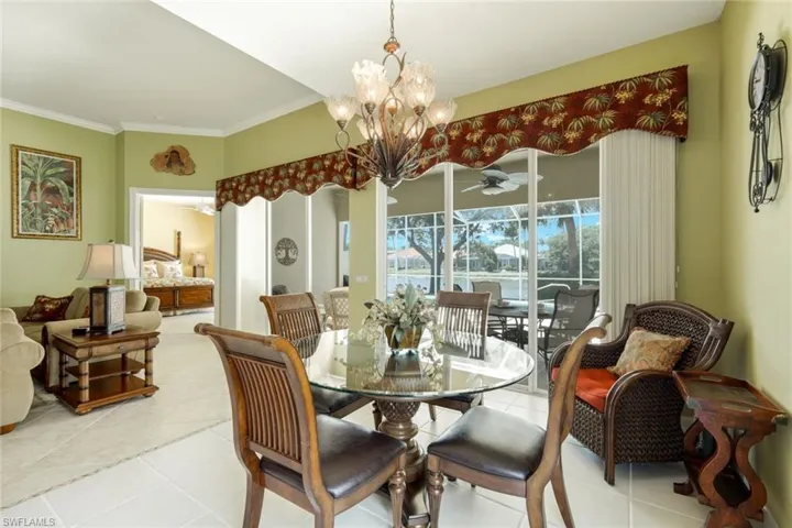 Dining area featuring a glass-top table, decorative chandelier, and ceramic tile flooring