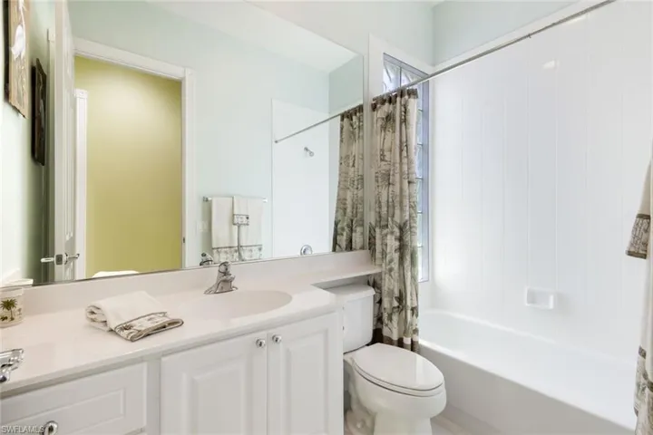 Bathroom featuring a white vanity with integrated sink, chrome faucet, and storage cabinetry