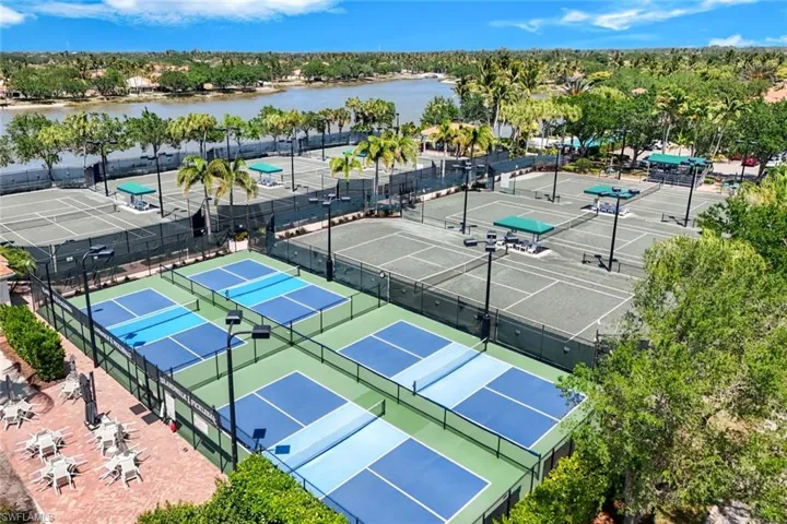 Extensive outdoor recreation area featuring multiple tennis courts, dedicated pickleball courts, and riverside landscaping