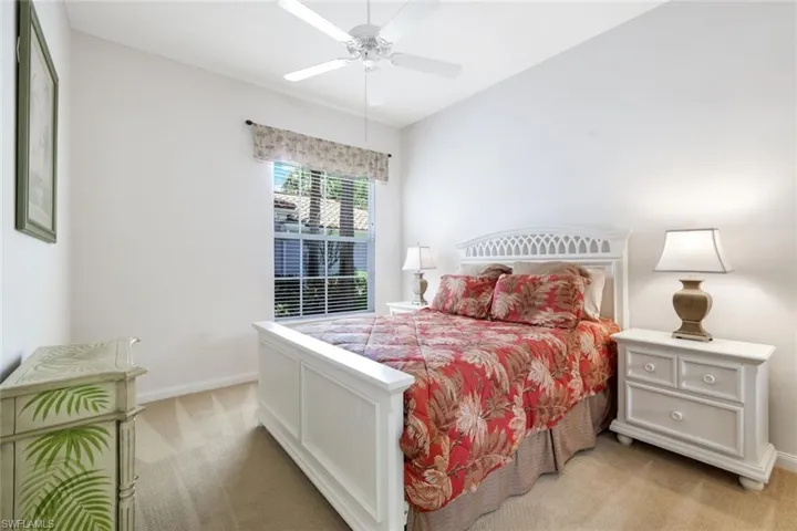 Carpeted room featuring a window with blinds, white walls, and a ceiling fan