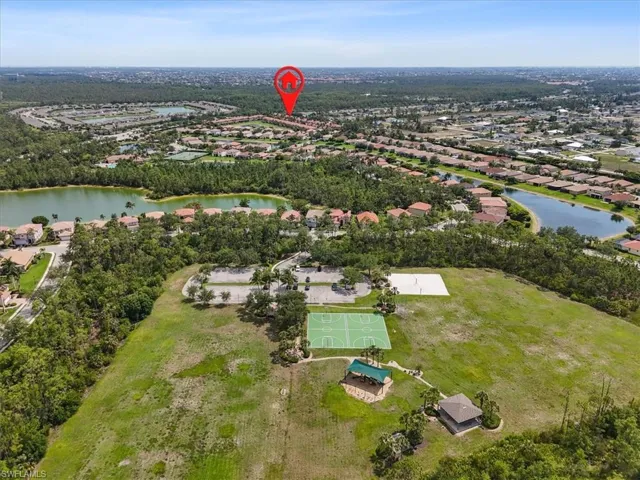 Aerial view of property and surrounding area with a nearby body of water and nearby suburban area