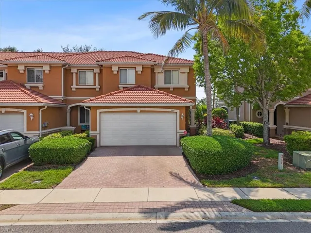 Mediterranean / spanish-style house featuring stucco siding, a tiled roof, decorative driveway, and a garage