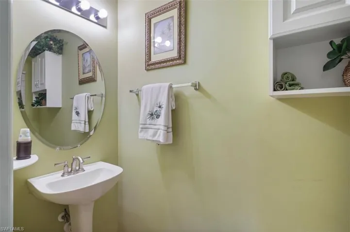 Kitchen with stainless steel appliances, arched walkways, wood finish cabinets, and light tile patterned floors