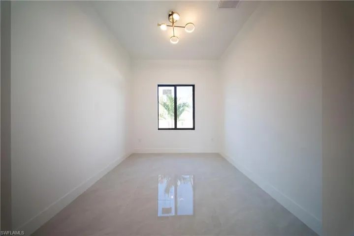 Spare room featuring hanging lights and a high ceiling