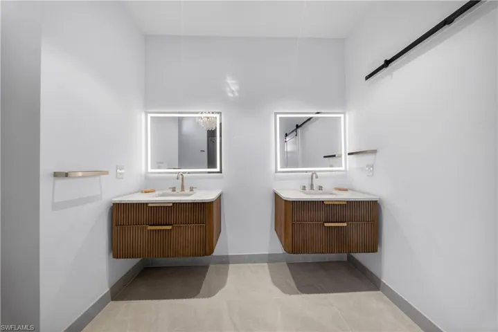 Bathroom with vanity, a soaking tub, walk in shower, a chandelier, and light tile patterned floors