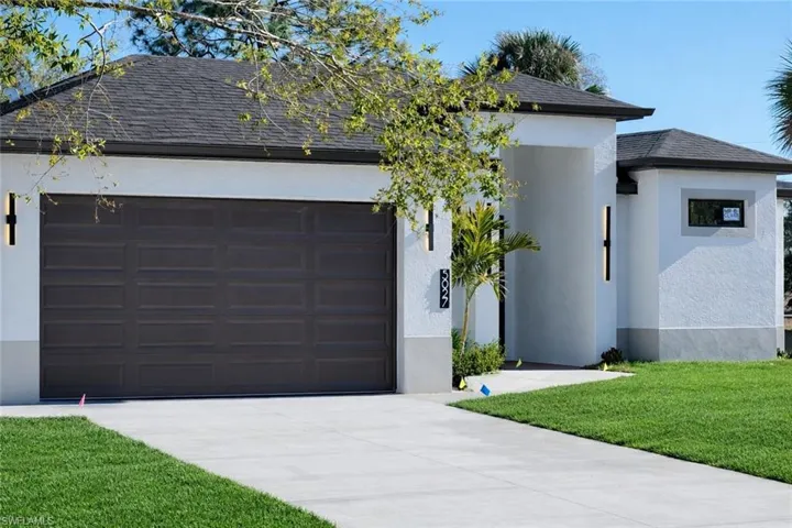 View of front of house with a front lawn, stucco siding, roof with shingles, and concrete driveway