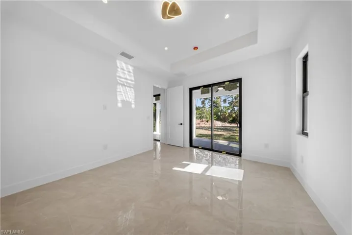 Empty room with recessed lighting and a raised ceiling
