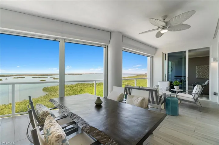 Sunroom featuring wood finished floors and a deck with water view